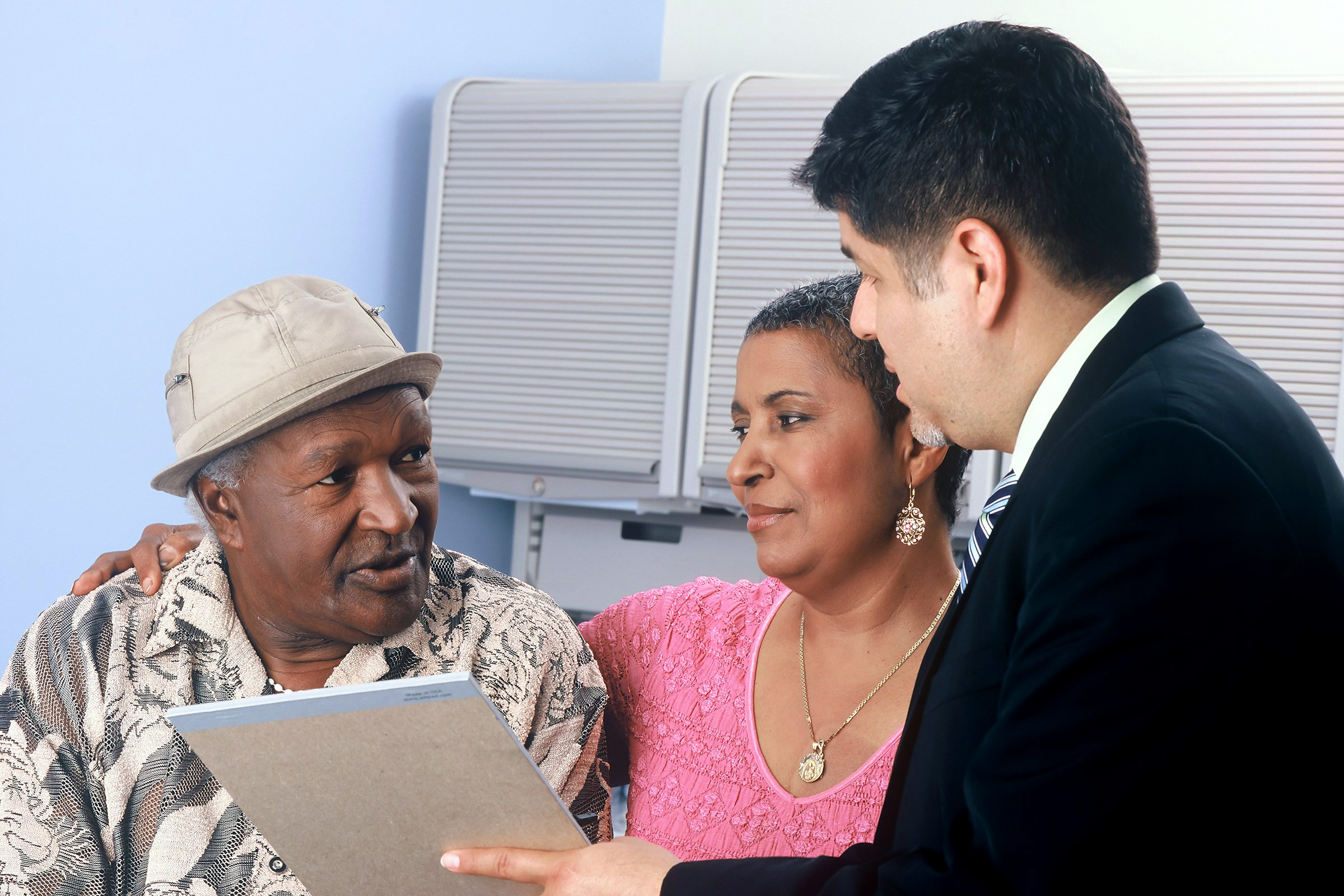 An agent going through plan options on a tablet with an older couple